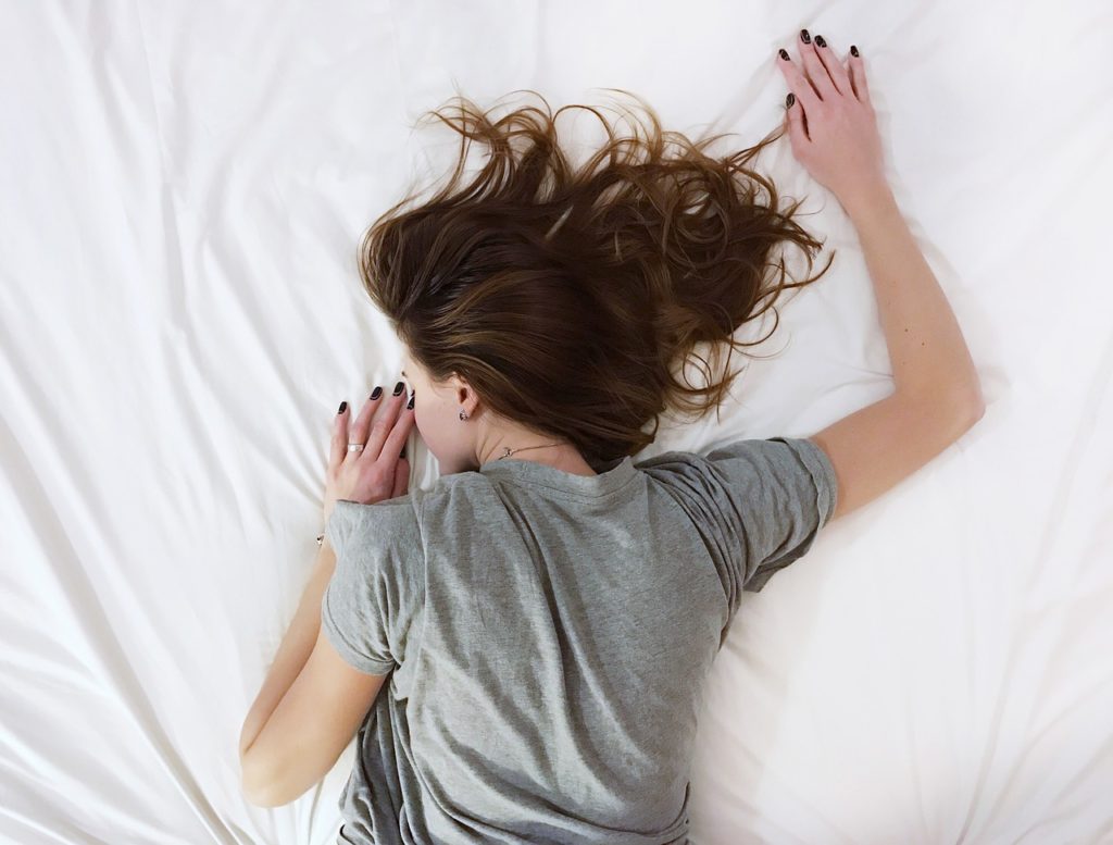 Person sleeping on stomach in bed