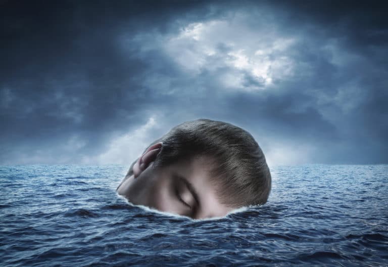A half-submerged head floating on a sea of water