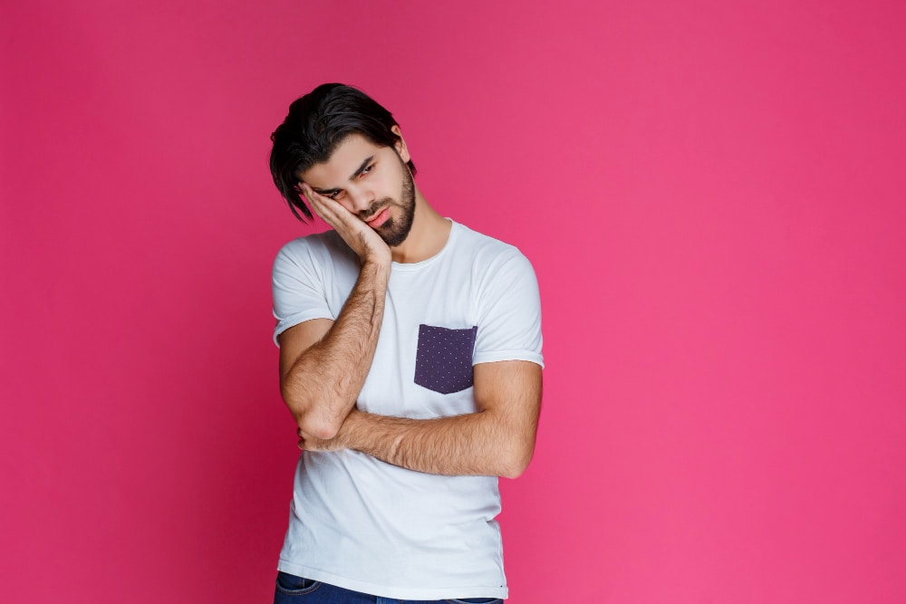 Exhausted man holding his face in his hands