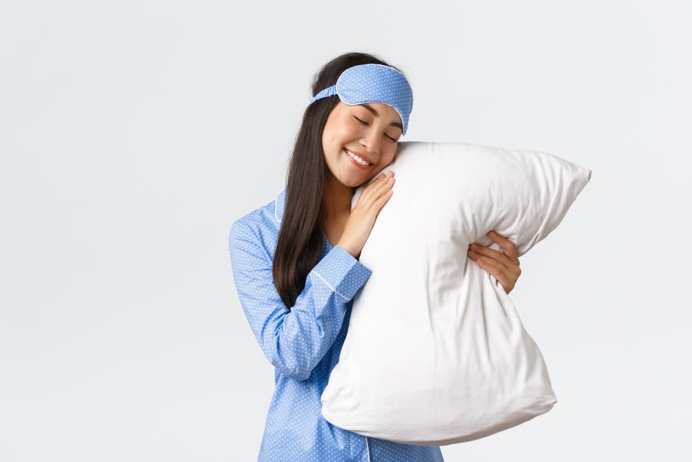 person cuddling a pillow close to face