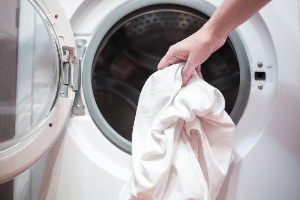 Linen being put into a washing machine
