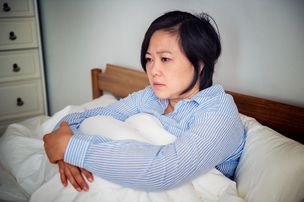 Woman staring blankly ahead in bed